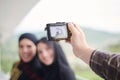 A man takes a photo of muslim women with a camera