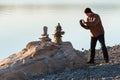 Man takes picture of balancing rocks