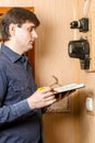 A man records the readings of an electricity meter Royalty Free Stock Photo