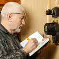 A man records the readings of an electricity meter Royalty Free Stock Photo