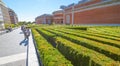 Man takes a smoke break beside the labyrynth of diagonal rows of shrubbery behind Prado Museum in Madrid Spain. Royalty Free Stock Photo