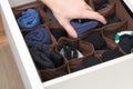 A man takes socks and panties folded according to the method of Marie Kondo. Vertical storage of clothes in chest of