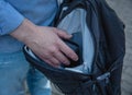 A man takes some item from a backpack