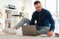 Man Taking Notes Using Laptop Sitting On Floor At Home Royalty Free Stock Photo