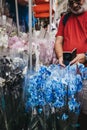 Man taking a photo of blue orchid on his mobile phone at the Columbia Road Flower Market, London, UK.