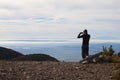 Man taking a photo of a foggy landscape