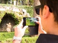 man taking photos with his cell phone in carmen de los martires park in granada spain Royalty Free Stock Photo