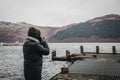 Man taking photos on a pier on Loch Lomond in Scotland