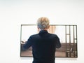 Man taking picture of artwork in museum room.