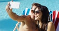 Man taking picture of himself with wife at pool Royalty Free Stock Photo