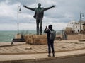 Man taking picture of a statue in Polignano a Mare, Puglia, Italy