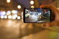 Man taking a picture in the street with his mobile phone. Night l Royalty Free Stock Photo