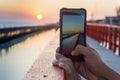 Man taking picture of the sunset with mobile phone Royalty Free Stock Photo