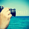Man taking a picture and the text smile!, with a retro effect Royalty Free Stock Photo