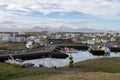 Man taking pictures of the harbor in Iceland with mountains in the background Royalty Free Stock Photo