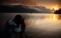 Man taking pictures photographer of a sunrise over a lake between the mountains Royalty Free Stock Photo