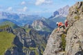 Man taking pictures secured to a via ferrata cable, high up on Delle Trincee klettersteig, in the Dolomites mountains Royalty Free Stock Photo