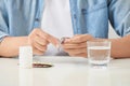 Man taking pill out from blister pack at home