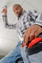 Man taking pliers from toolbelt reaching up Royalty Free Stock Photo