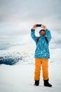 Man taking selfie with smartphone on mountains background