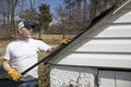 Man taking shingles off a shed roof Royalty Free Stock Photo