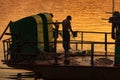 Man taking a shower at the end of working day over Chindwin river at sunset