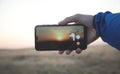 Man taking sunset with his smartphone