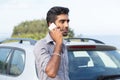 Man talking on a cell phone leaning on the door of his car Royalty Free Stock Photo