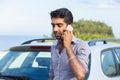 Man talking on a cell phone leaning on the door of his car Royalty Free Stock Photo