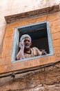 Man talking on cellphone while holding cigarette through window Royalty Free Stock Photo