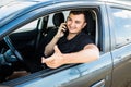 Young man talking on his phone and driving a car Royalty Free Stock Photo