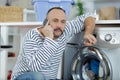 man talking on mobile phone while putting laundry Royalty Free Stock Photo