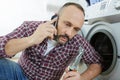 man talking on mobile phone while putting laundry Royalty Free Stock Photo