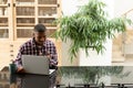 Man talking on mobile phone while using laptop on worktop in kitchen Royalty Free Stock Photo