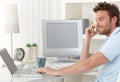 Man talking on phone using computer Royalty Free Stock Photo