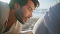 Man talking pregnant tummy woman sitting beach close up. Happy future father Royalty Free Stock Photo