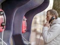 Young man talking on a red street payphone Royalty Free Stock Photo