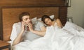 Man cheating on girlfriend talking with lover while she is sleeping in the background Royalty Free Stock Photo