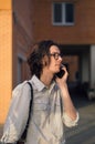 Man is talking on smartphone in front of modern building. Royalty Free Stock Photo