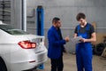 Repairman talking to a man about a car repair Royalty Free Stock Photo