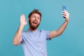 Man talking on video call and waving hello gesture, having online conversation on mobile phone. Royalty Free Stock Photo