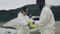 Man taping bacteriological protective gloves to a woman