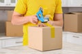 Man taping box with adhesive tape dispenser in kitchen, closeup Royalty Free Stock Photo