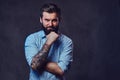 A man with tattoo on arm dressed in a shirt. Royalty Free Stock Photo