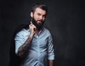 A man with tattoo on arm dressed in a shirt. Royalty Free Stock Photo