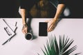 Man with tattoo holding tablet on office desk table with , supplies, flower and cup of coffee. Top view Royalty Free Stock Photo