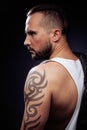 A man with tattooes on his arms. Silhouette of muscular body. caucasian brutal hipster guy with modern haircut, looking