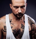 A man with tattooes on his arms. Silhouette of muscular body. caucasian brutal hipster guy with modern haircut, looking