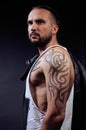 A man with tattooes on his arms. Silhouette of muscular body. caucasian brutal hipster guy with modern haircut, looking Royalty Free Stock Photo