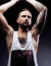 A man with tattooes on his arms. Silhouette of muscular body. caucasian brutal hipster guy with modern haircut, looking Royalty Free Stock Photo